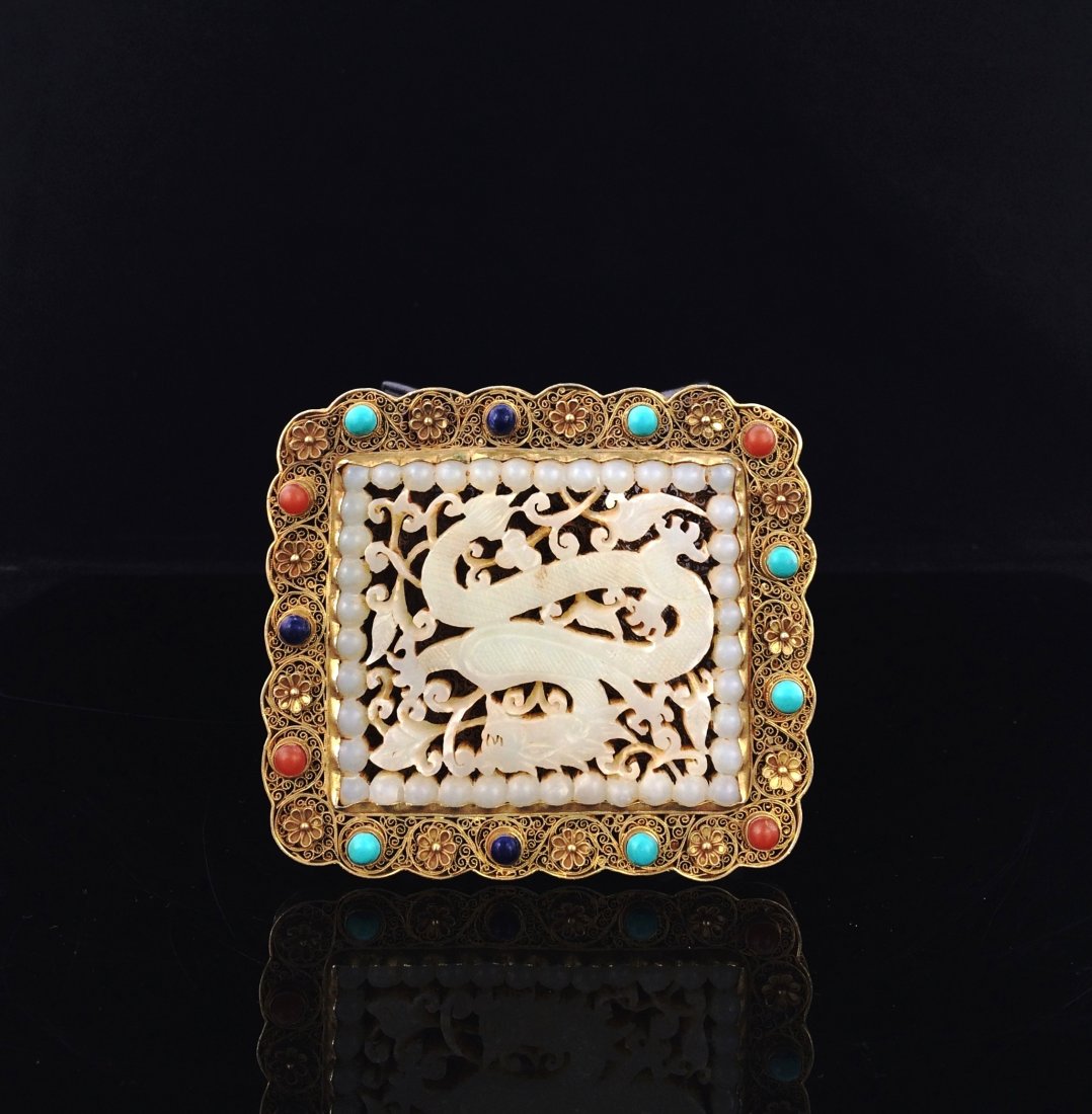 A RARE CARVED WHITE JADE FILIGREE PLAQUE: Chinese Filigree and White Jade Plaque. The convex pendant plaque is well carved in openwork as square medallion enclosing a dragon in flight amidst the scrolling twigs with contorted bodies flanking