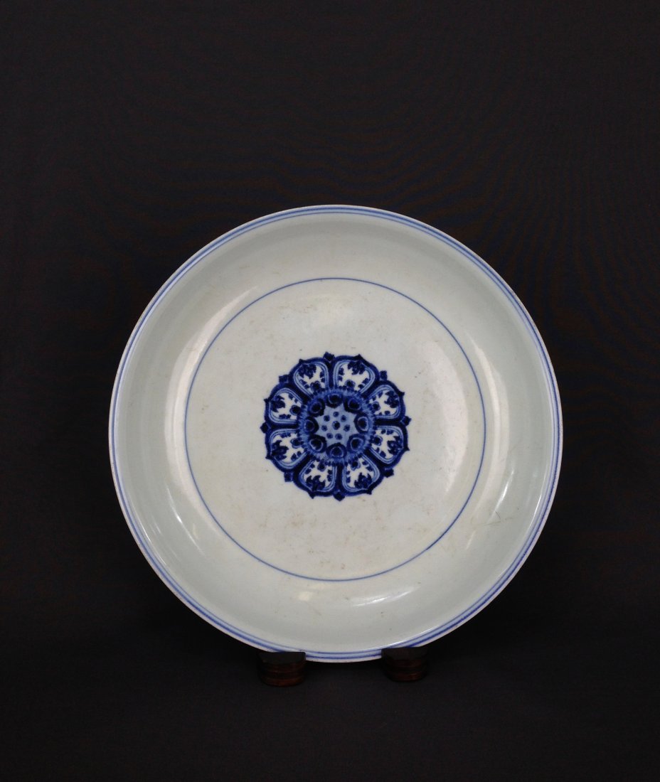CHINESE BLUE AND WHITE PORCELAIN PLATE: Chinese Blue and White Porcelain Plate. Decorated with geometrical lotus throne petals on the center, surrounded by single circular lines. Unglazed base. Dimension: 1-3/4"H x 11"Diam