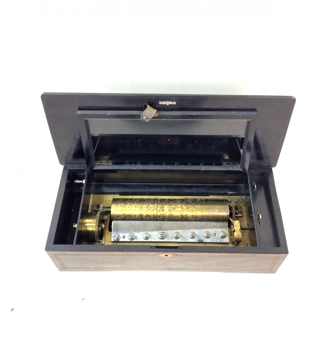 SWISS Mahogany Inlaid Cylindrical Music Box: SWISS Mahogany Inlaid Cylindrical Music Box An antique wooden music box in good working condition that plays six songs. Wooden case has a beautiful inlay in a variety of wood types. No key present but