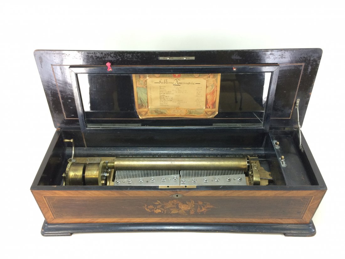 Antique Swiss Mahogany Inlaid Cylindrical Music Box: Antique Swiss Mahogany Inlaid Cylindrical Music Box An antique wooden music box in good working condition that plays six songs. Wooden case has a beautiful inlay in a variety of wood types. No key pre