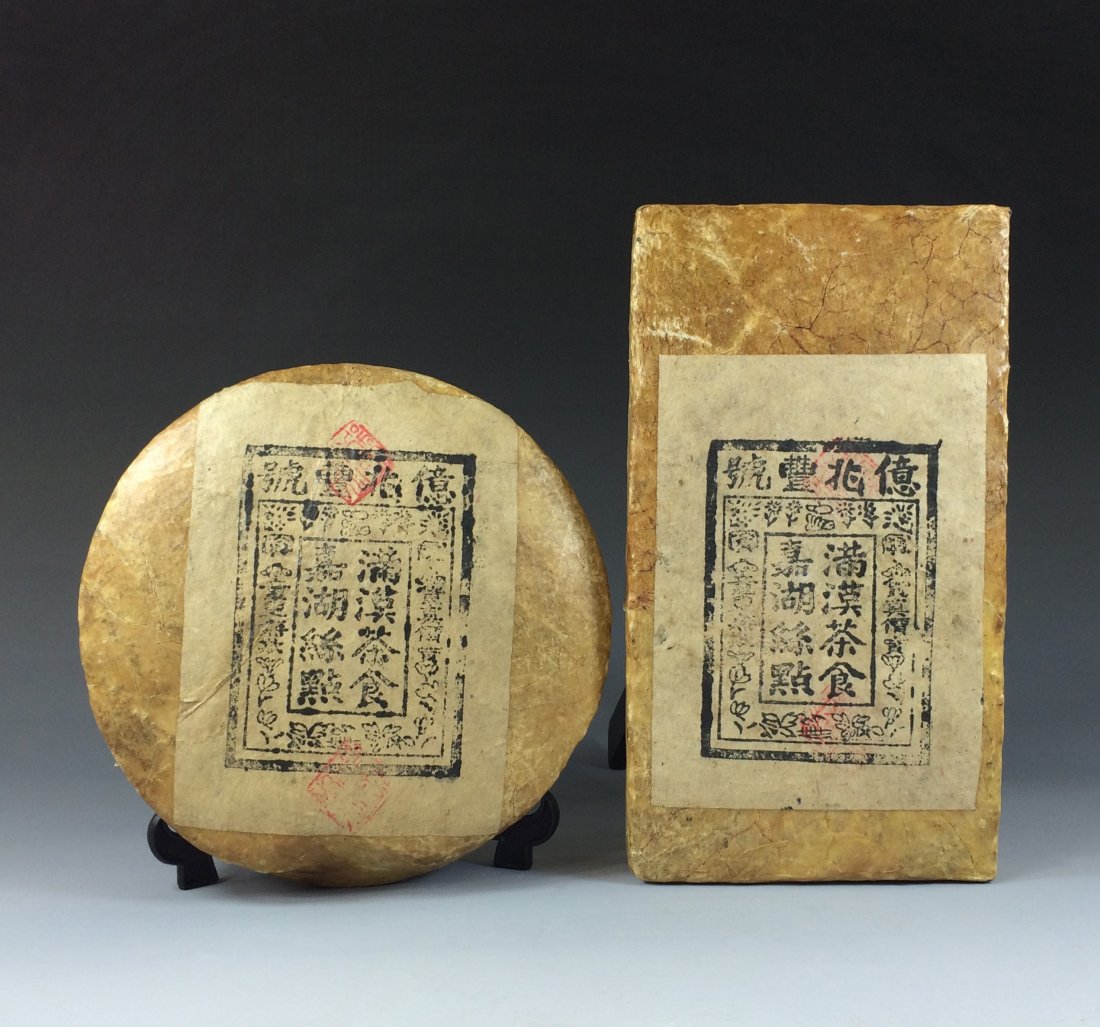 2 PCS OF BLOCK AGED CHINESE PUER TEA: 2 (Two) PCS Of Block Aged Chinese PuEr tea wrapped with Ox skin paper. Round and rectangular wrapped. Dimension: (Left) 7-1/4"Diam. Weight: 1.5 LB (Right) 9-1/2"L x 5-1/4"W x 1-1/2"D, Weight: 2 LB