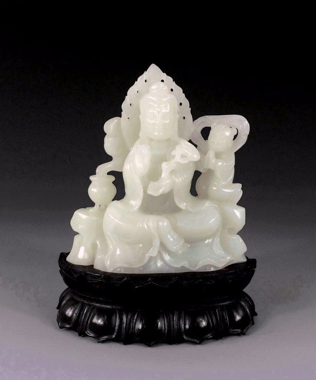 A FINE CARVED WHITE JADE OF GUANYIN FIGURE: A Fine Carved Chinese White Jade of GuanYin Figure; wearing elongated robe with headrest, hands holding a ruyi scepters, seated in full lotus position above the pedestal, with aura-chakra behind her h