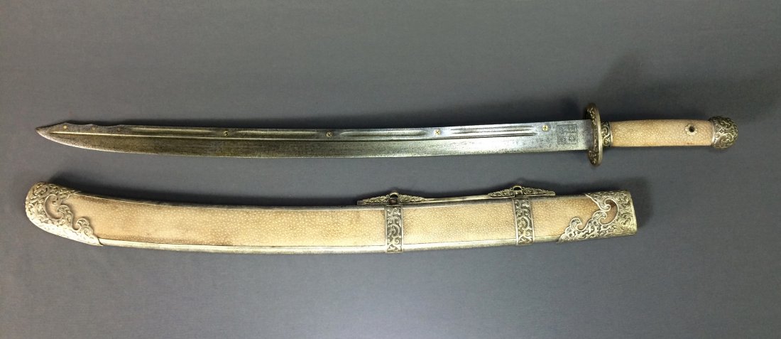 CHINESE SHARK SKIN CEREMONIAL SABER: Chinese Shark Skin Ceremonial Saber. Prob. Qing Dynasty, an Shark Skin Ceremonial saber and scabbard, Qianlong mark, the elongated 'S'-shaped saber, intricately open carved in relief with Dragons patt