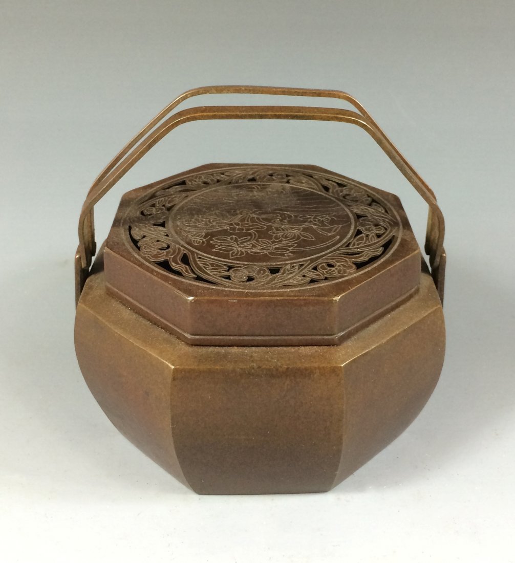 AN ANTIQUE BRONZE HEXAGONAL HAND WARMER: An Antique Chinese Bronze Hand Warmer. A Hexagonal bulbous -shaped box, flanked swing handle on the body with fitted Lid. Openwork decoration of carved forked twigs surrounded central medallion. Mark 