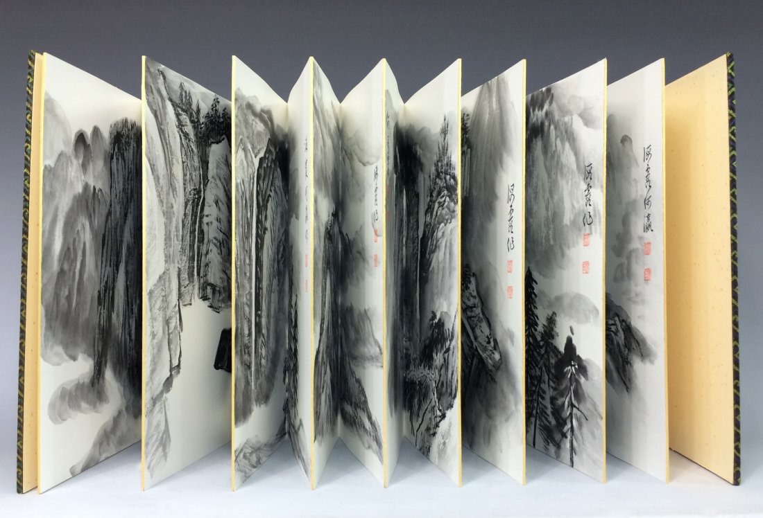 A CHINESE WATERCOLOR ALBUM PAINTING BOOK: A Chinese Watercolor Album Painting Book; watercolor on paper, hard-covered with blue metallic silk. Hand painting "shanshui"- a waterside panoramic of misty mountain scene. Showing artist's calligrap