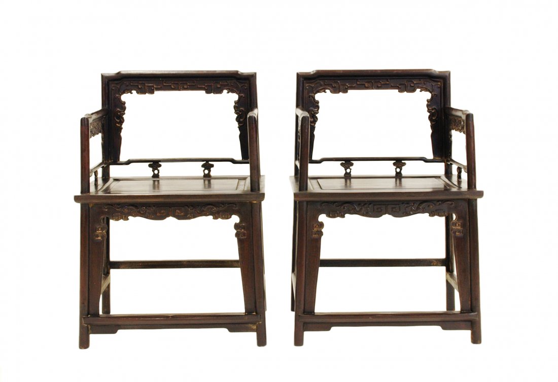 PAIR OF CARVED ZITAN ROSE CHAIRS, MEIGUI YI: Each with an open-carved back frame formed by a straight top rail rounding the corners to the back posts, set with an inset beaded border apron and spandrels finely carved with archaistic T-scrolls, t