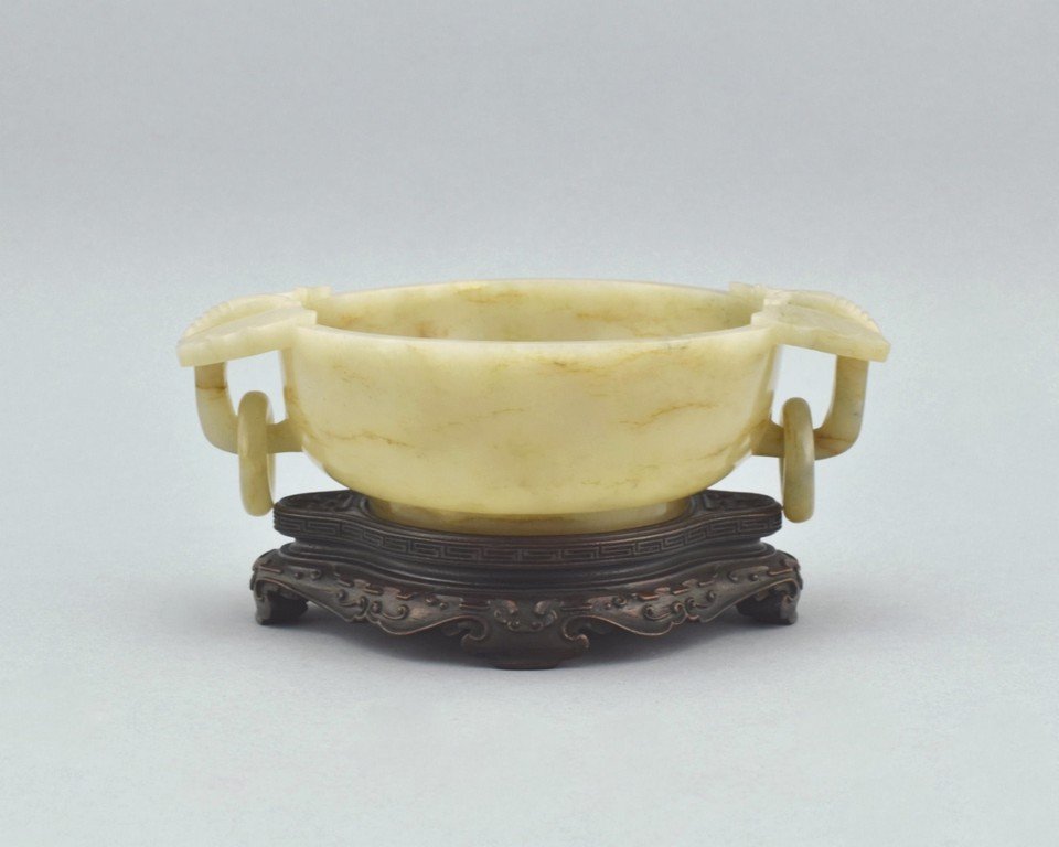 JADE BRUSH WASHER OF CATFISH AND SWASTIKA INTERIOR ON: The jade brush washer of simply deep bowl with two elephant mask holding ring emerged from the shoulder, the interior carved with two cat-fish encircled the shaped swastika symbol. The cat fish (nian)