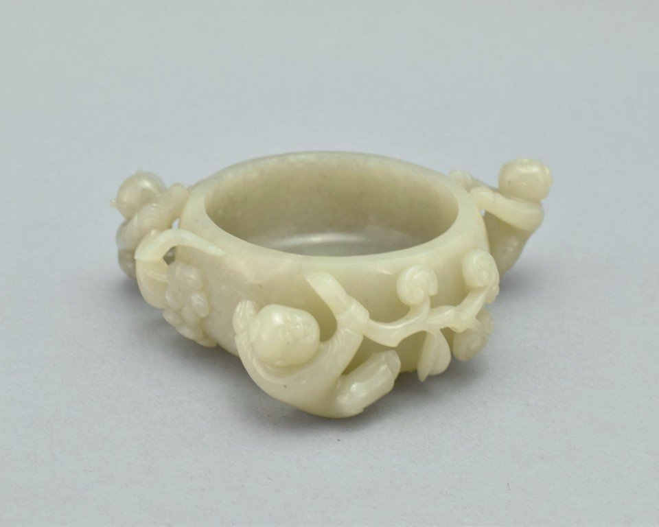 JADE BRUSH WASHER WITH CHILDREN AND LINGZHI FUNGUS: Having a bulbous vessel body with wide opening further to smooth hollow interior, two scrolling lingzhi fungus branches flanked on the shoulder, while three children playfully hung unto the handles. T