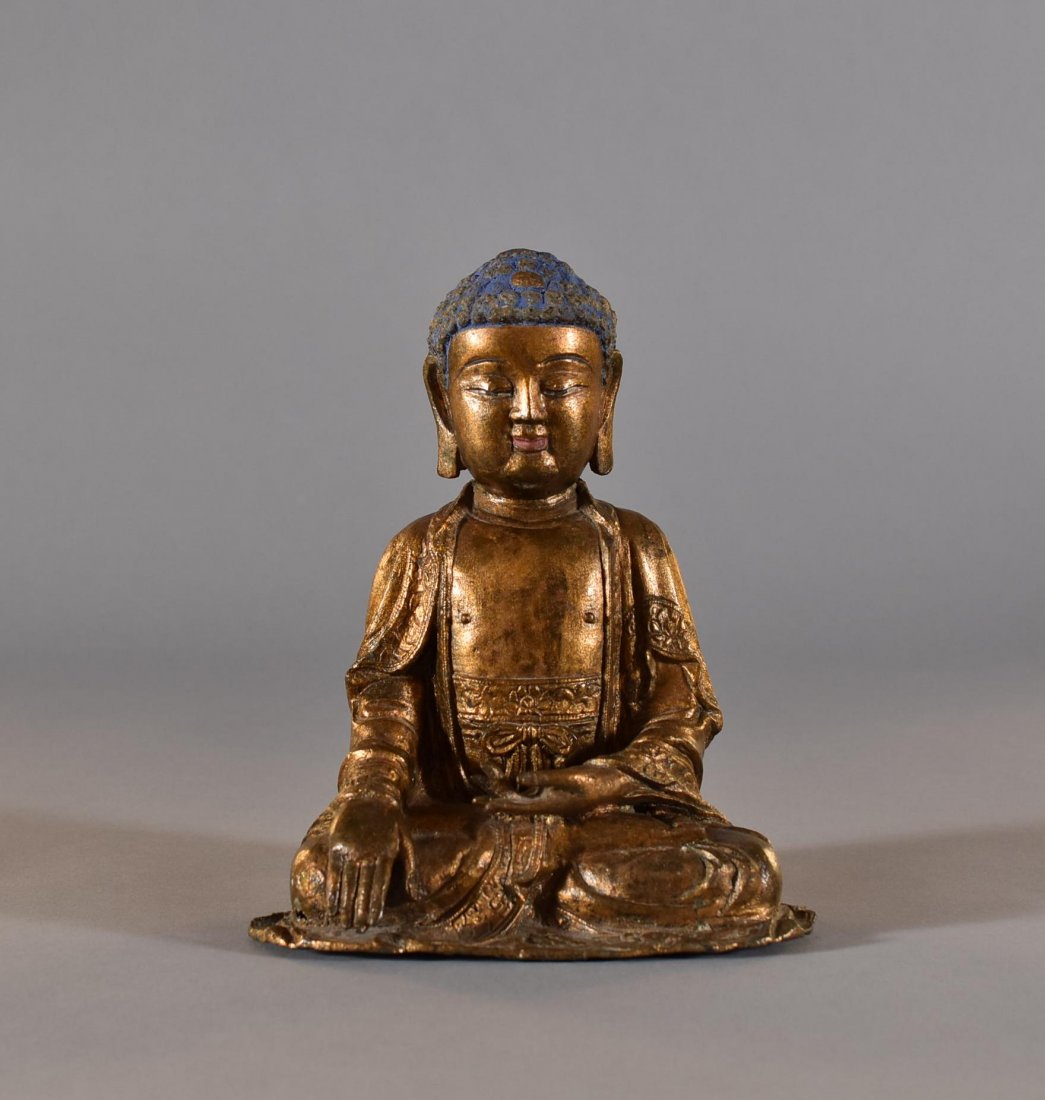 MING DYNASTY GILT BRONZE SEATED BUDDHA: CHINESE MING DYNASTY PERIOD (1368-1644) GILT BRONZE SEATED BUDDHA The figure is finely cast and shown seated in dhyanasana with loosely draped folds of the robe. Hands in Bhumiparsa-Dhyana Mudra gestu