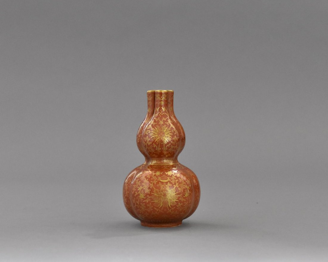 FINE GILT OVERGLAZED OX-BLOOD DOUBLE GOURD PORCELAIN: The vase having a unique shape of double triple Flori-form petal double gourd body, with three straight neck further to three narrowed opening, raised upon concave triple Flori-form footed ring. The e
