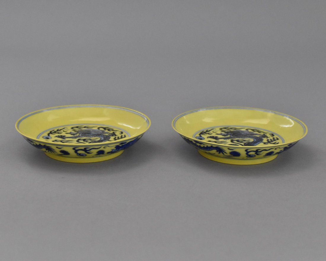 PAIR FAMILLE JAUNE DRAGON PLATE, QIANLONG MARK: The shallow plate having the center interior decorated in cobalt blue hand painting depicted enormous imperial dragon soaring between flames and clouds in the pursuit of the flaming pearl. The rim lef