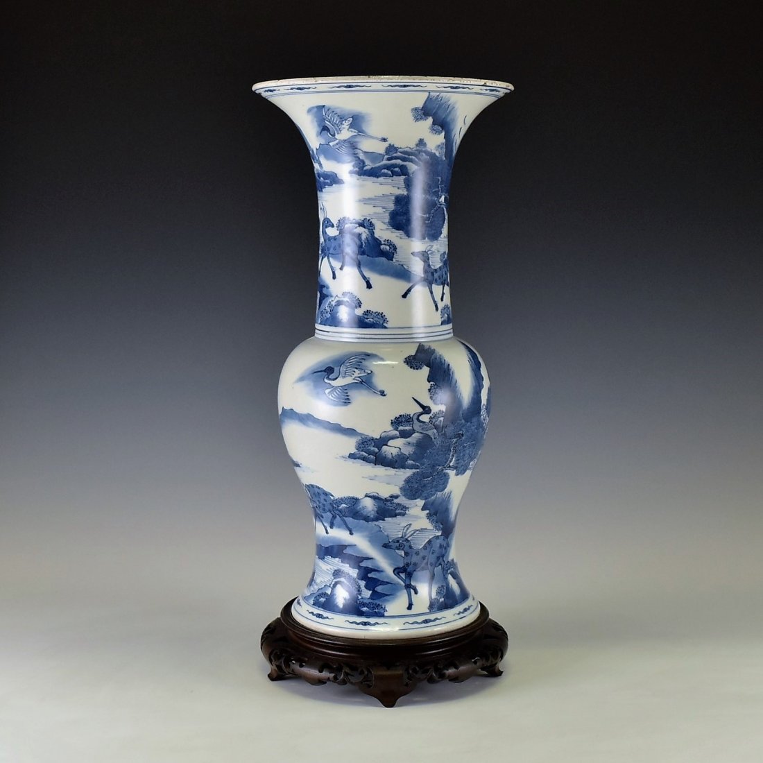 DEER & CRANE YEN YEN VASE ON STAND: The vase potted in shape of a phoenix tail, Chinese porcelain traditional yen yen shape. The beaker having baluster shaped body, with bulging belly, trumpet-shaped neck are painted in tones of rich un