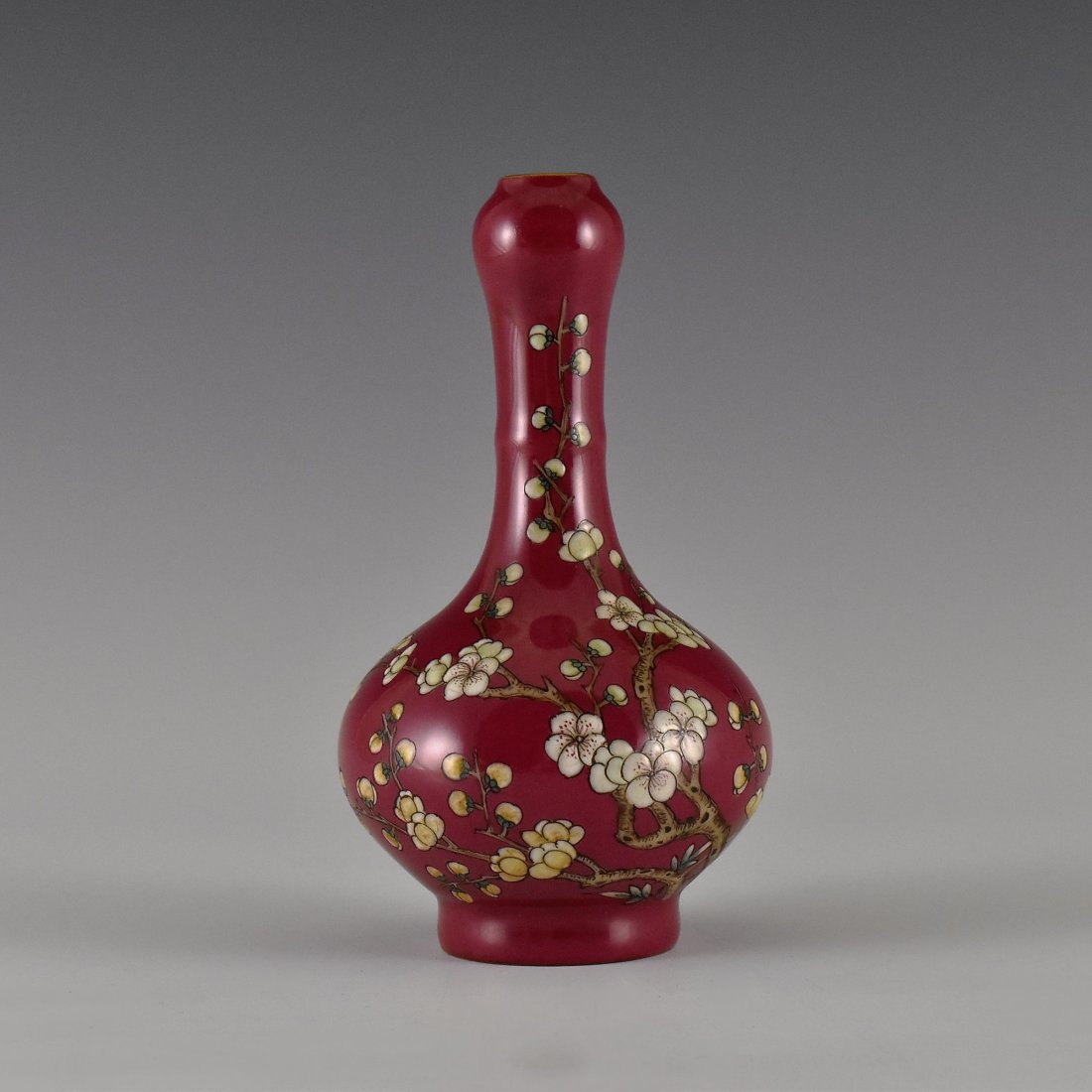 PLUM MOTIF ON AUBERGINE GROUND GARLIC VASE: Potted to slightly tapered globular body, with tall neck rising toward knobbed rim and narrow opening, supported upon footed base. The exterior hand painted with vivid branching flowering prunus tree,