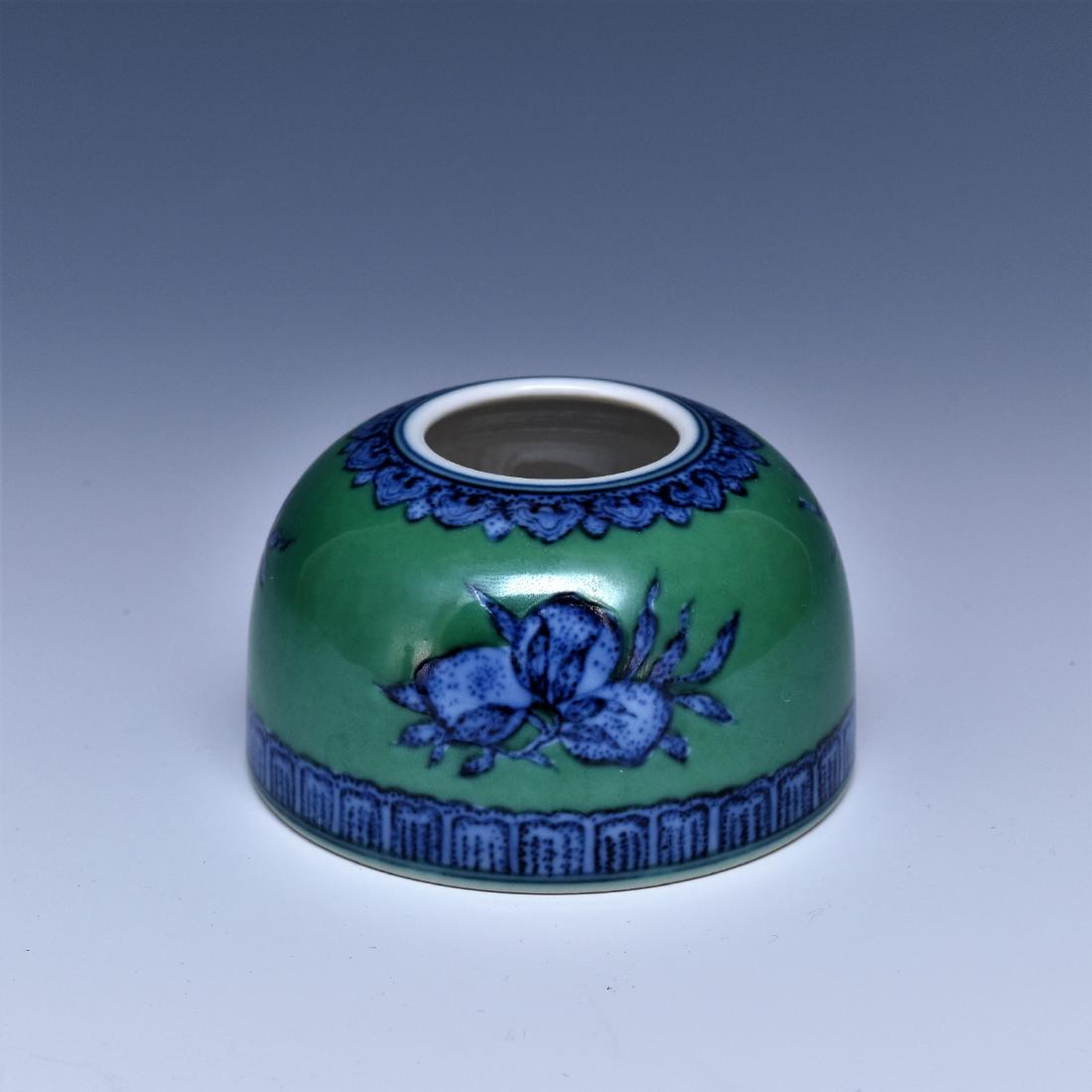 FRUITS ABUNDANT MOTIF ON GREEN BRUSH WASHER: A deep vessel with bell shaped body with flat base and narrow opening, the exterior decorated with hand painting in cobalt-blue underglazed of three fruits abundant over jade-green ground, bordered wi