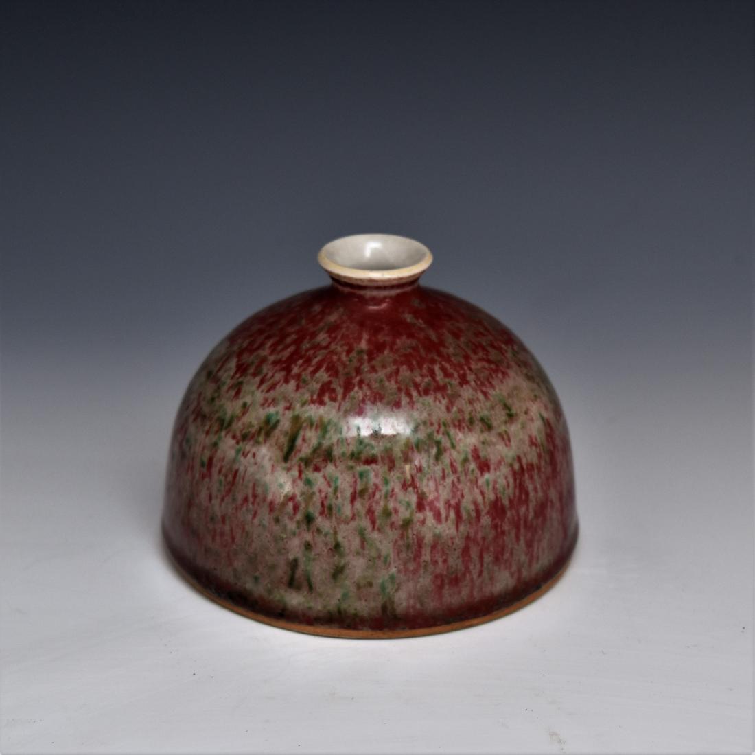 SANG DE BEOUF BELL SHAPED BRUSH WASHER: Chinese porcelain potted into a deep vessel with bell shaped body with flat base, rounded shoulder toward short neck, flared rim and narrow opening. Slightly concave base with small foot. The exterior