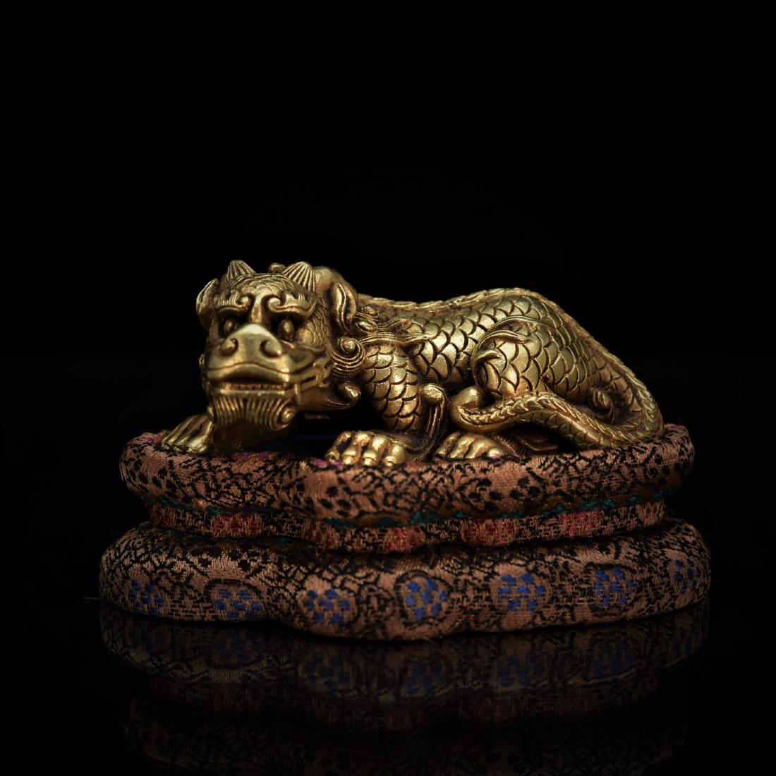 GILT BRONZE MODEL OF QILIN ON BASE: Finely casted Chinese gilt bronze in model of a mythical beast Qilin, generally have Chinese dragon-like features. Eyes with thick eyelashes, manes that flow slightly upward and beards. The body is fu