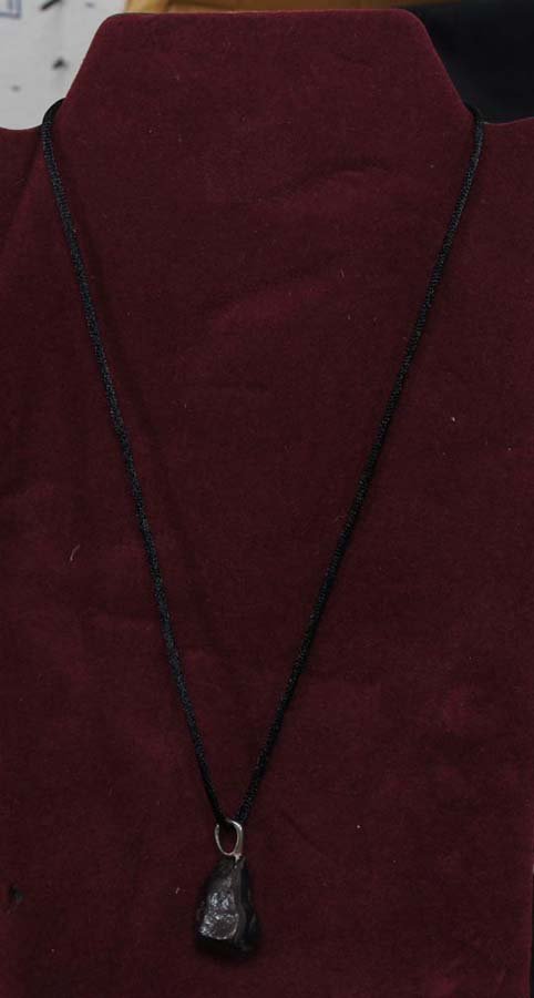 METEORITE PENDANT, ,: Title: polished meteorite specimen with cord to use to hang as jewelry. Certificate of Authenticy notes that the work is magnetic iron-nickle and was found in Nantan China from a meteor strike in 1546