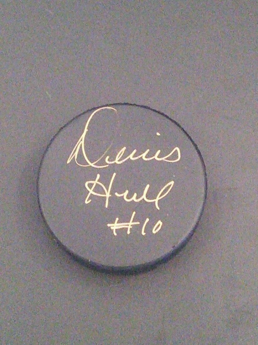 Dennis Hull #10 Signed Hockey Puck JSA G10642: Dennis Hull #10 Signed Hockey Puck JSA G10642. Dennis William Hull (born November 19, 1944) is a retired professional ice hockey left winger who played most of his career for the Chicago Black Hawks o