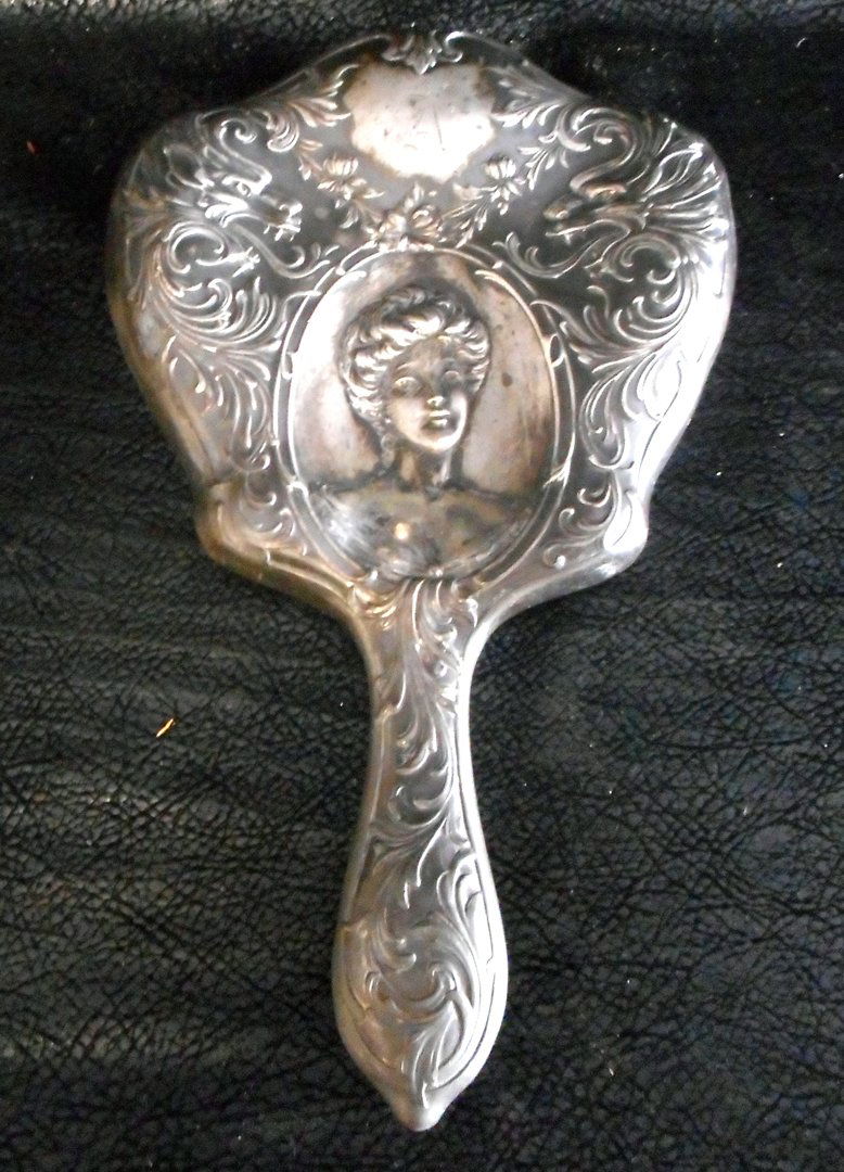 Old Victorian Metal hand mirror: This mirror is most probably pre 1900. The design is victorian and the mirror handle and frame are metal. It is a hand mirror and it's length is about 10 inches.