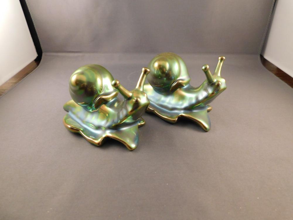 Pair of Zsolnay Art Pottery Snails: Zsolnay Hungarian pair of art pottery iridescent green snails. Measures approx. 2 1/2" tall x 4" wide. You are bidding at a live sale. Please Read the terms and conditions. We are offering scheduled p