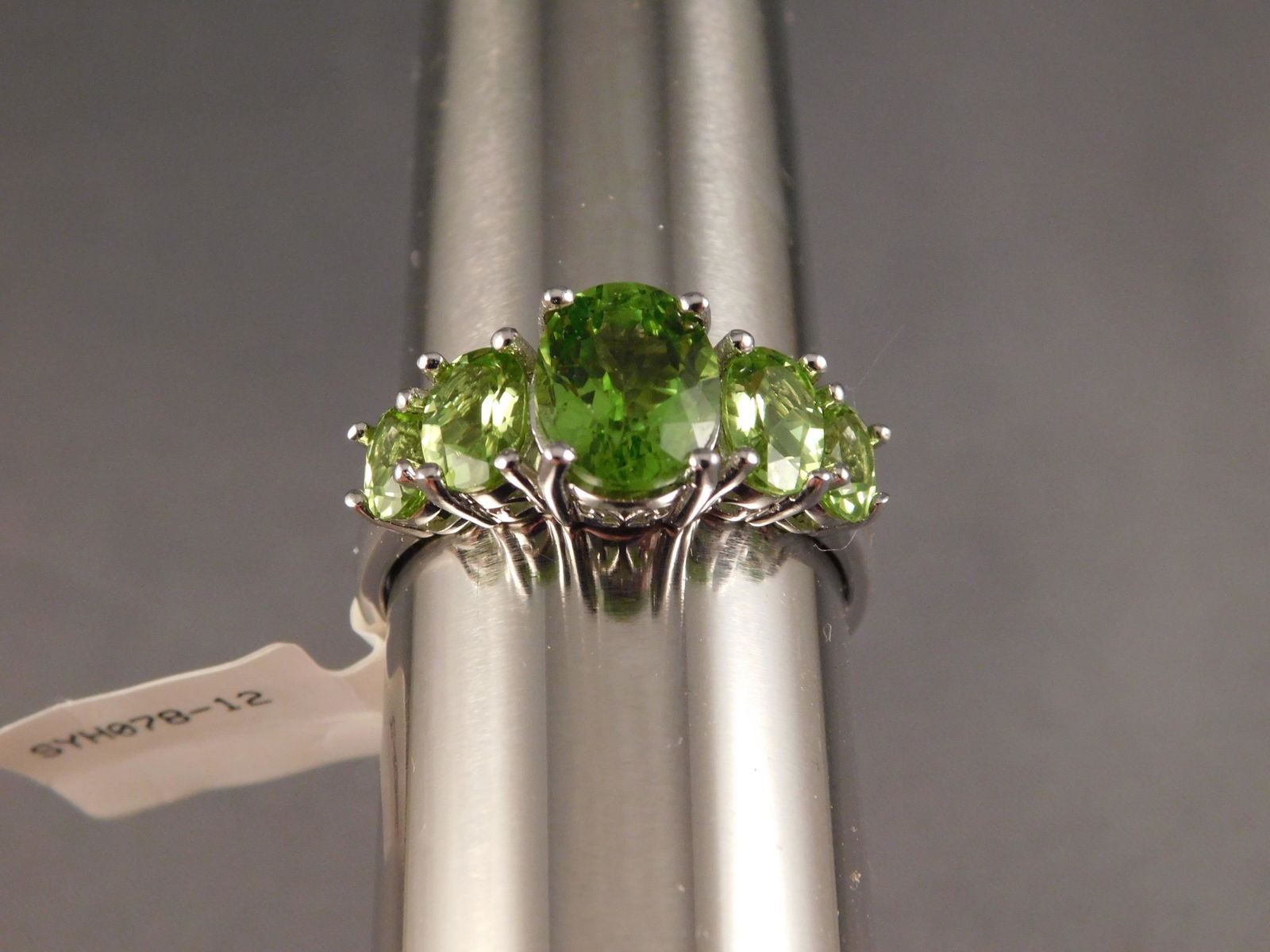 Sterling Silver Ring: Sterling silver ring with green stones along the top. Size 12. You are bidding at a live sale. Please read the terms and conditions. We are offering appointment only no contact pick-up at our South Br