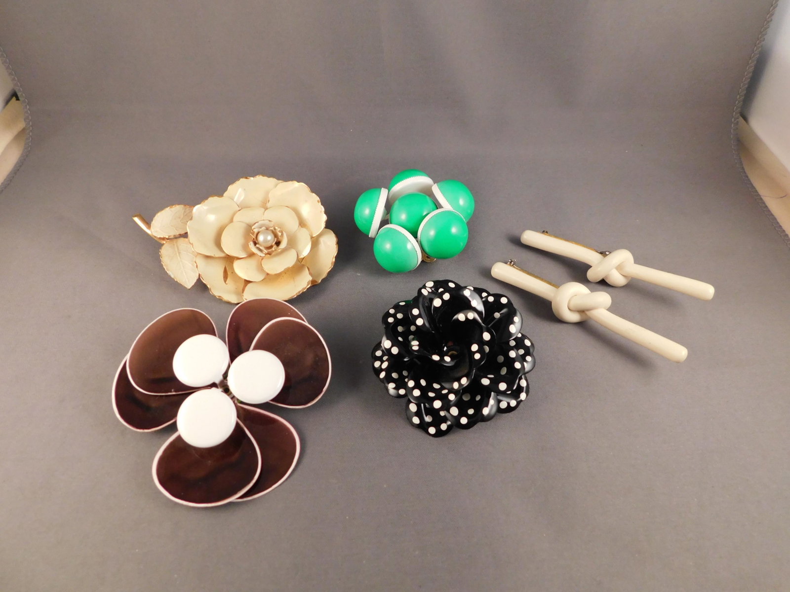 6 Vintage Pins: Lot of 6 vintage brooch/pins. One has some loss on the white petal. They measure between 2" and 3". You are bidding at a live sale. Please read the terms and conditions. We are offering appointment on