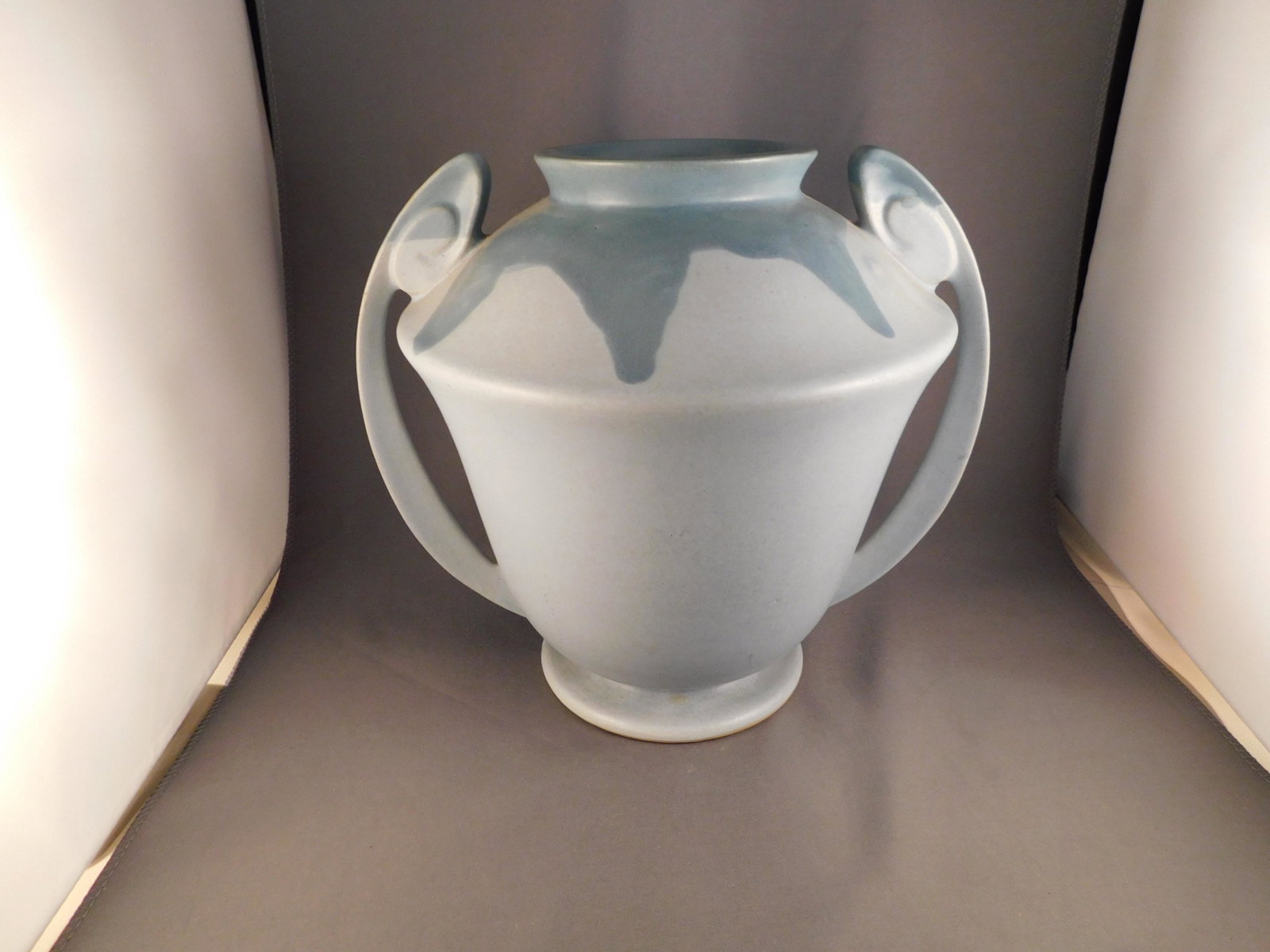 Roseville Carnelian I Double Handled Vase: Roseville art pottery Carnelian I double handled vase. Measures approx. 8" tall x 8" in diameter. You are bidding at a live sale. Please read the terms and conditions. We are offering contactless pick