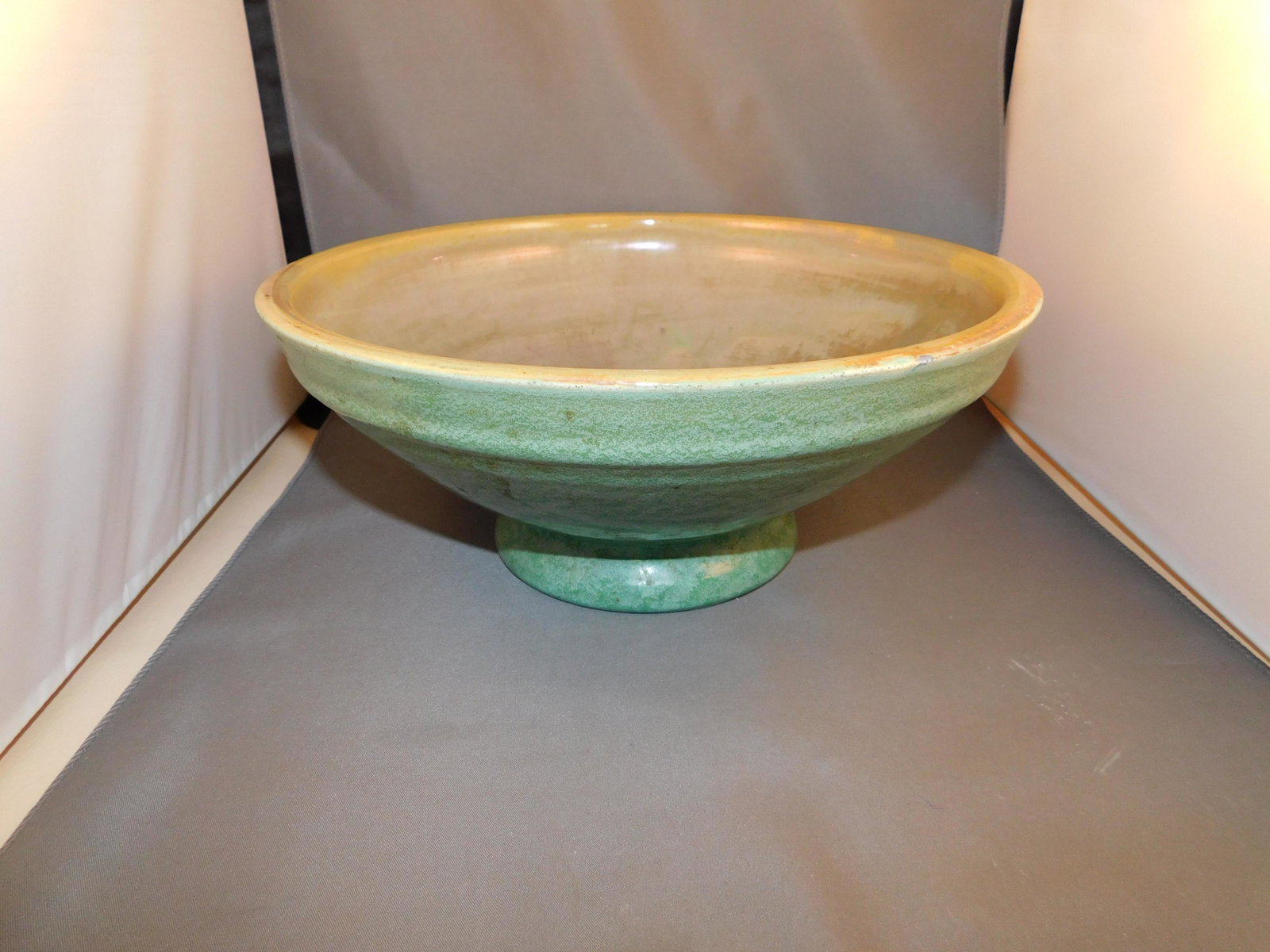 Pewabic Detroit Bowl: Pewabic Detroit art pottery bowl in a green finish with a green iridescent finish on the inside. Measures approx. 4 3/4" tall x 11 1/4" wide. You are bidding at a live sale. Please read the terms and 