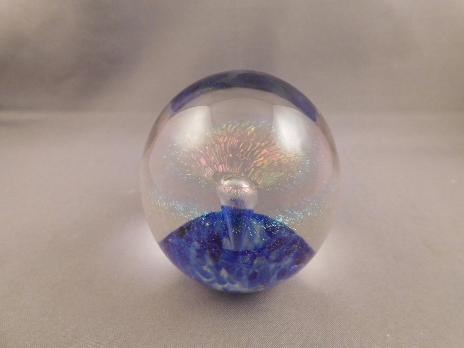 Eickholt Art Glass Paperweight: Eickholt art glass paperweight. Signed 1999 with iridescent speckles inside. Measures approx. 2 3/4" tall x 2 1/4" wide. You are bidding at a live sale. Please read the terms and conditions. We are of