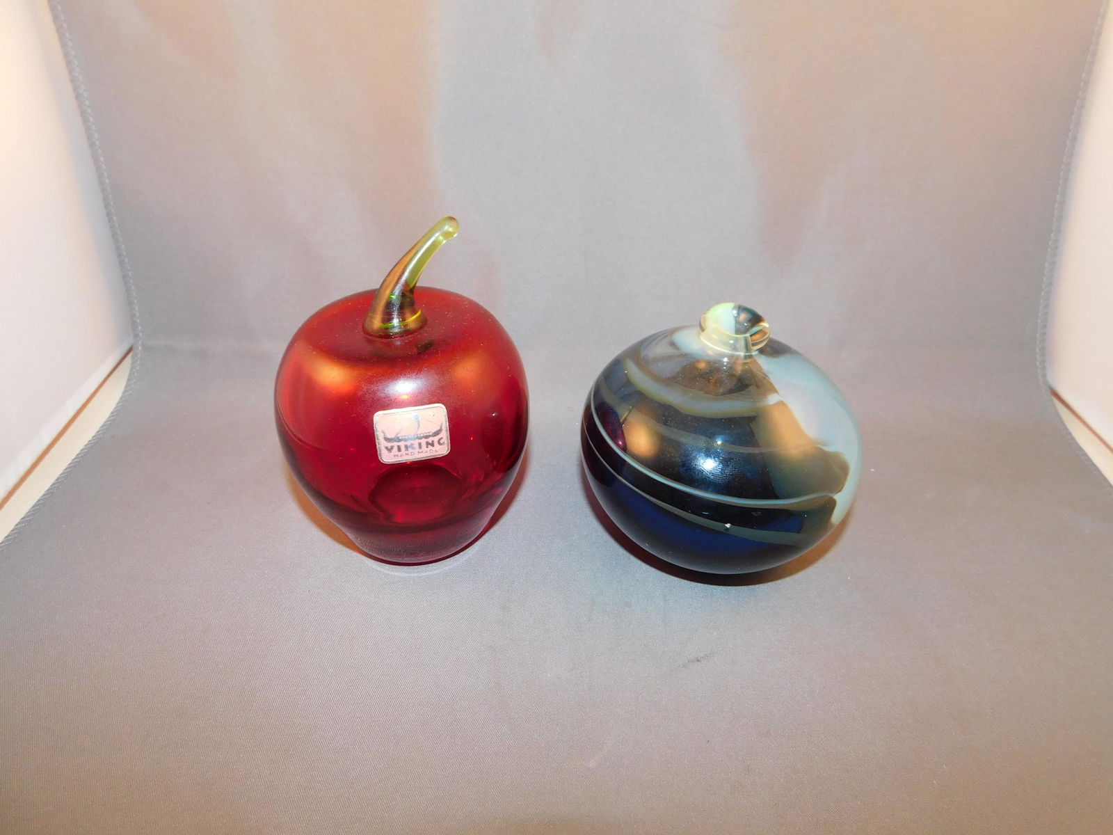 Art Glass Apple and Bud Vase: Art glass apple and bud vase. Measures approx. 3 1/4" - 4" tall x 3" - 3 1/4" wide. You are bidding at a live sale. Please read the terms and conditions. We are offering no contact pick up at our Sout