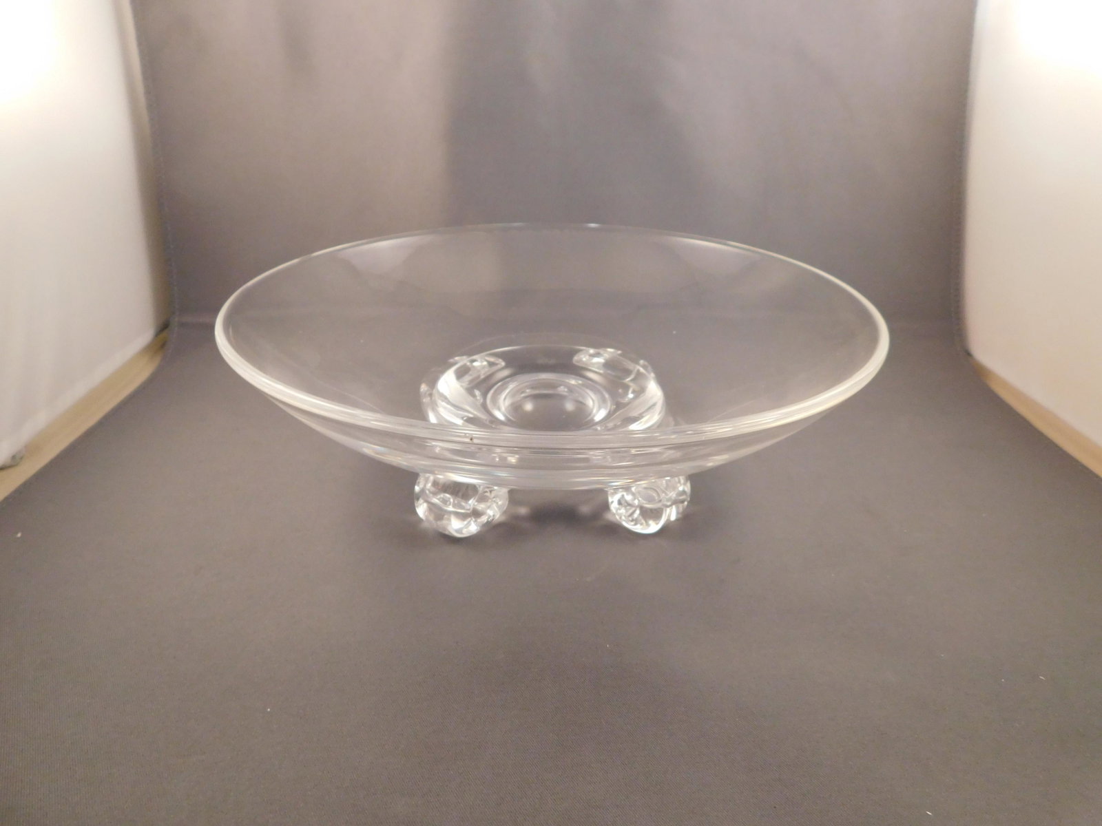 Stuben Art Glass Bowl: Art glass bowl signed Stuben. Has 4 feet on the bottom. Measures approx. 2 3/4" tall x 8" wide. You are bidding at a live sale. Please read the terms and conditions. We are offering no contact pick up