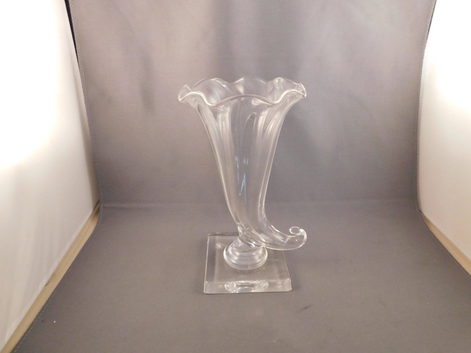 Stuben Art Glass Cornucopia: Art glass cornucopia, signed Stuben. Measures approx. 7" tall x 3 1/2" wide. You are bidding at a live sale. Please read the terms and conditions. We are offering no contact pick up at our South Bruns