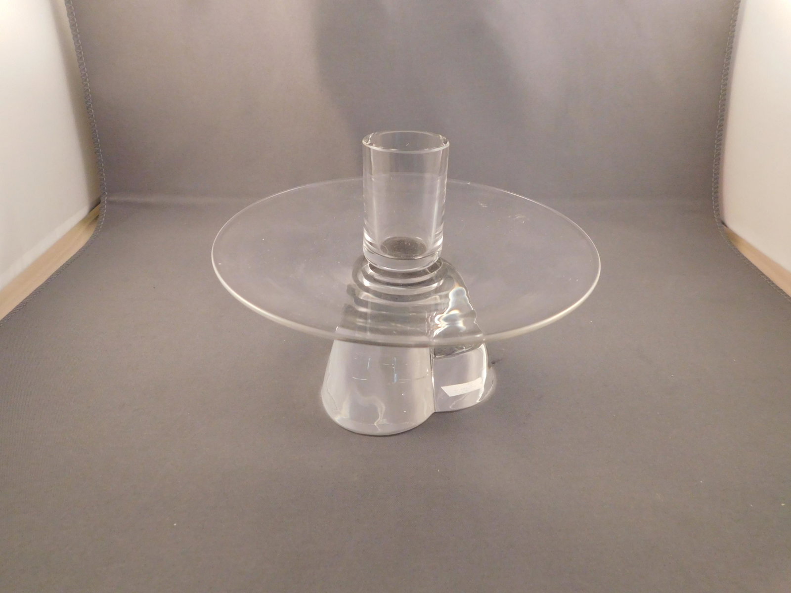 Stuben Art Glass Candlestick: Signed Stuben art glass candlestick. Measures approx. 4" tall x 5 1/2" wide. You are bidding at a live sale. Please read the terms and conditions. We are offering no contact pick up at our South Bruns