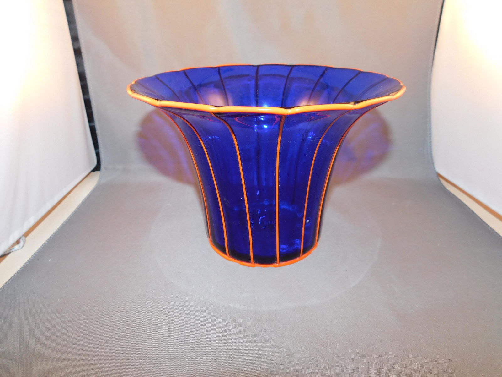 Art Glass Vase: Hand blown art glass vase in a cobalt blue with orange striping. Measures approx. 5 1/4" tall x 7 1/4" wide. You are bidding at a live sale. Please read the terms and conditions. We are offering no co