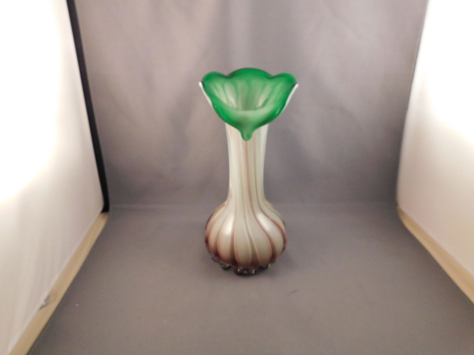 Art Glass Vase: Art glass bud vase with leaf style top. Measures approx. 7 3/4" tall x 3 1/2" wide. You are bidding at a live sale. Please read the terms and conditions. We are offering no contact pick up at our Sout
