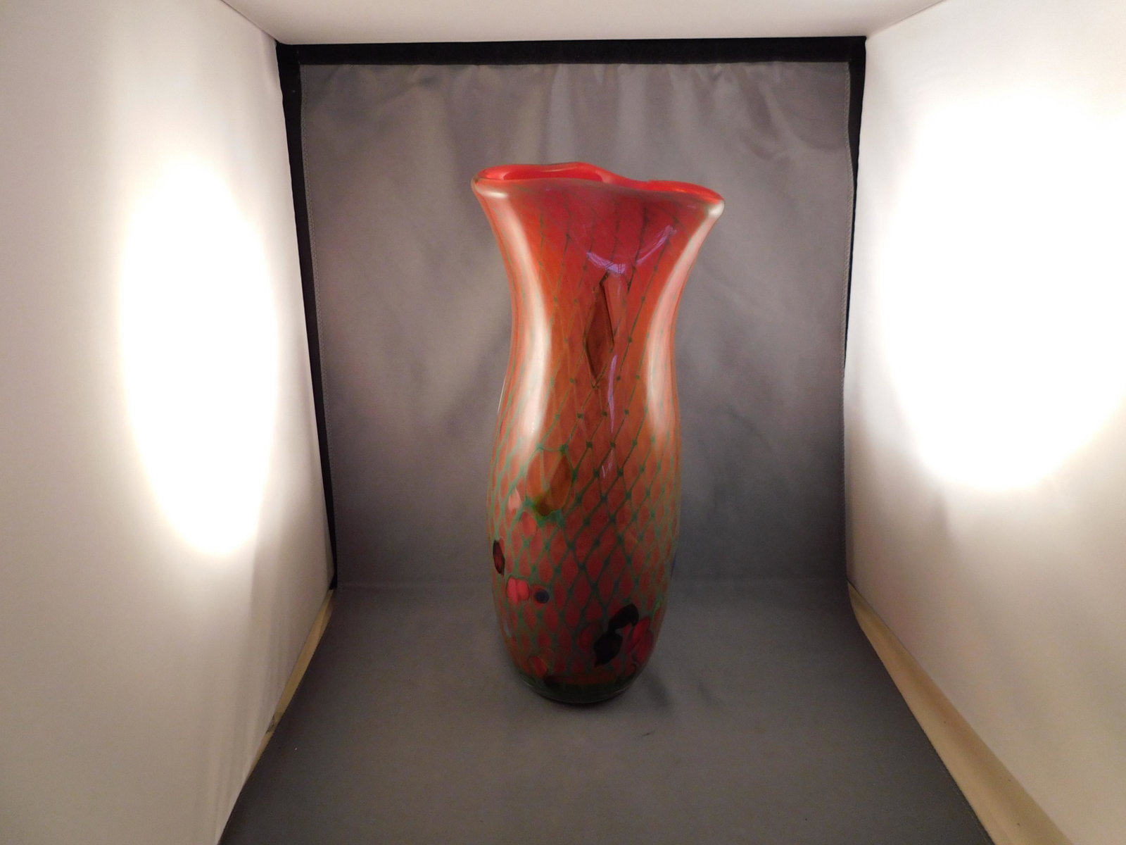 Art Glass Vase: Art glass tall vase in a multi colored pattern. Is signed on the bottom, but the signature is illegible. Measures approx. 12 1/2" tall x 4 1/2" wide. You are bidding at a live sale. Please read the te
