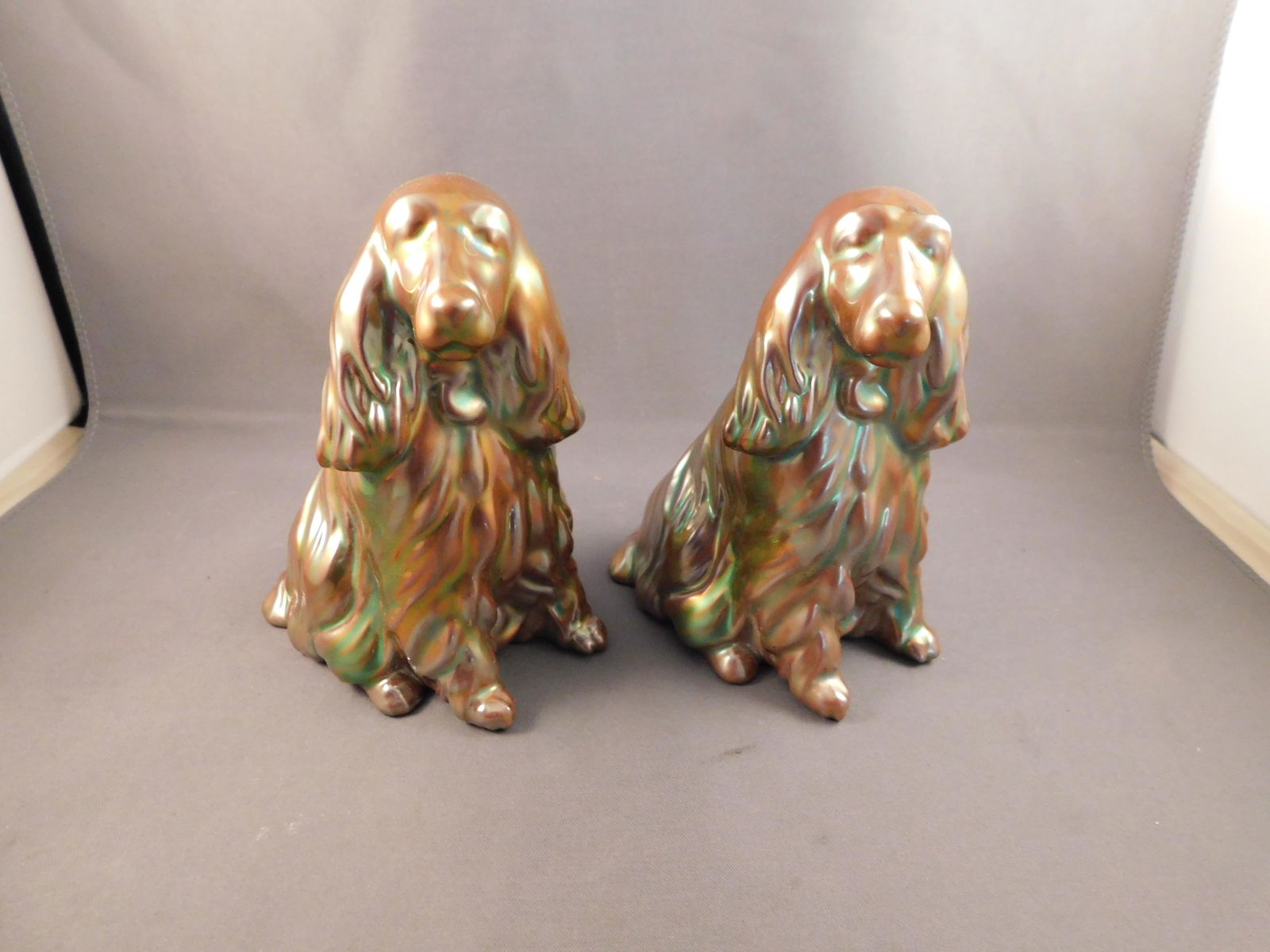 Pair of Zsolnay Dogs: Pair of iridescent gold Zsolnay dogs. Measures approx. 4 3/4" tall x 3 1/2" wide. You are bidding at a live sale. Please read the terms and conditions. We are offering no contact pick up at our South