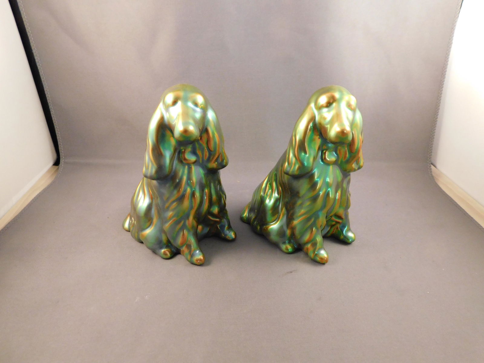 Pair of Zsolnay Dogs: Pair of iridescent green Zsolnay dogs. Measures approx. 4 3/4" tall x 3 1/2" wide. You are bidding at a live sale. Please read the terms and conditions. We are offering no contact pick up at our South