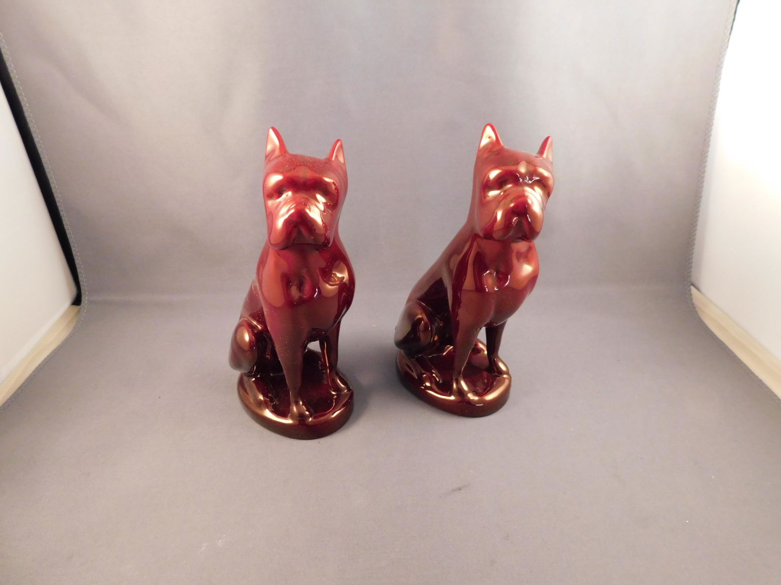 Pair of Zsolnay Dogs: Pair of Zsolnay red luster dogs. Measures approx. 5 1/4" tall x 3" wide. You are bidding at a live sale. Please read the terms and conditions. We are offering no contact pick up at our South Brunswick