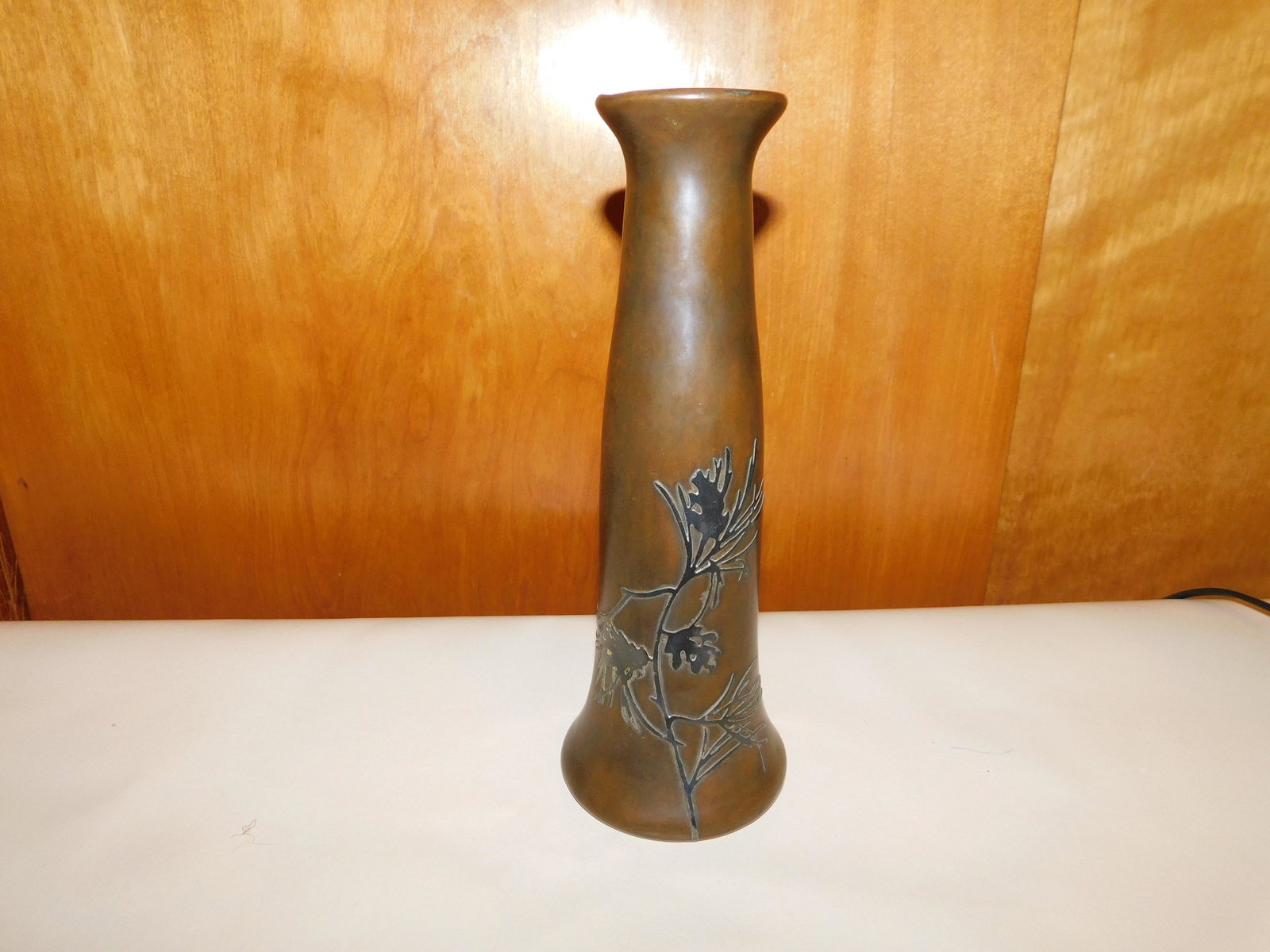 Bronze Vase: Bronze bud vase with sterling floral overlay. Marked AMS 3687A on the base. Measures approx. 10" tall x 3 1/2" wide. You are bidding at a live sale. Please read the terms and conditions. We are offeri