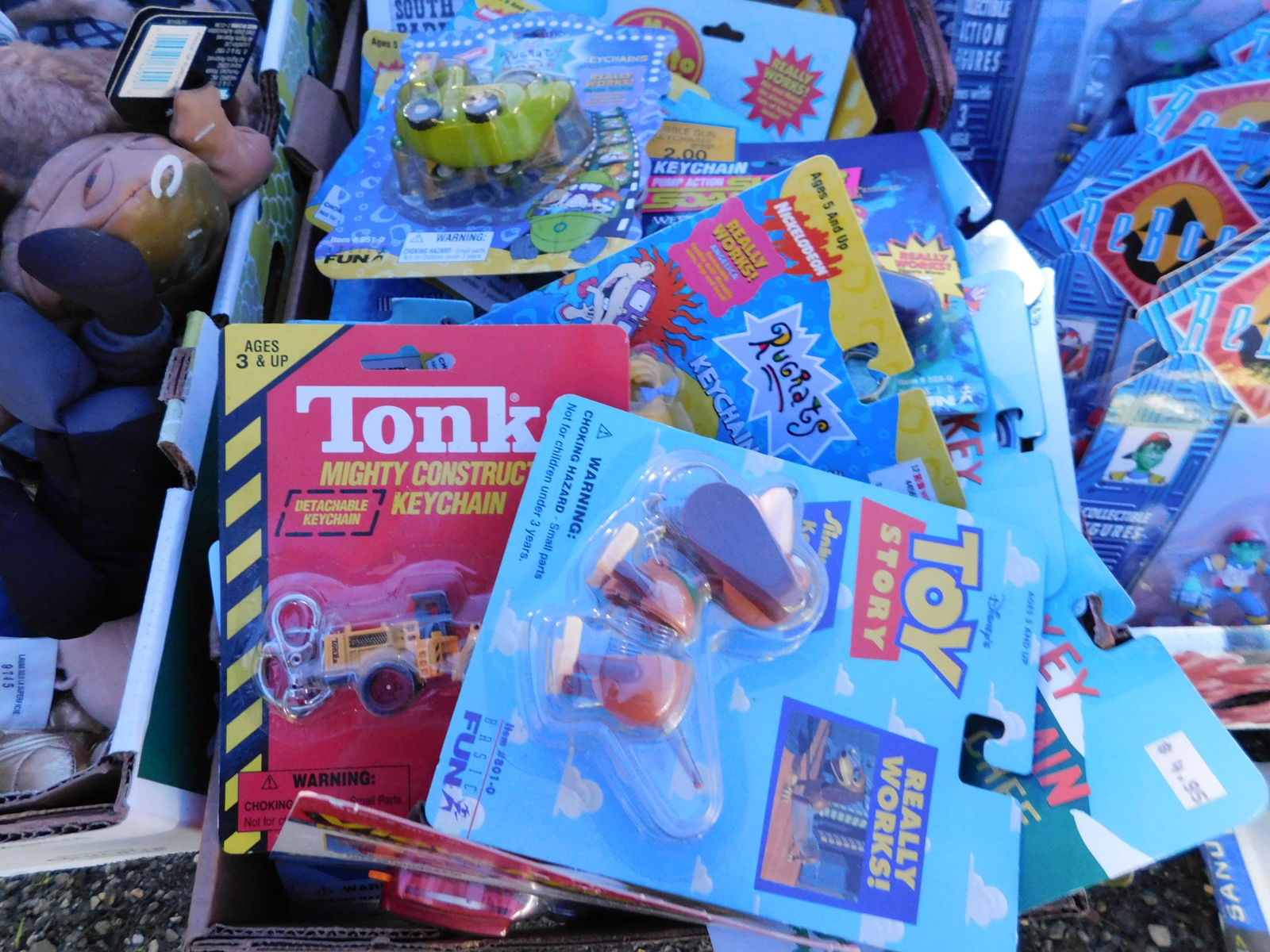 Lot of Pop-Culture Key Chains: Lot of misc. key chains including Tonka, Toy Story, Rugrats and more, all on card. May have some water damage. You are bidding at a live sale. Please read the terms and conditions. This sale will be b