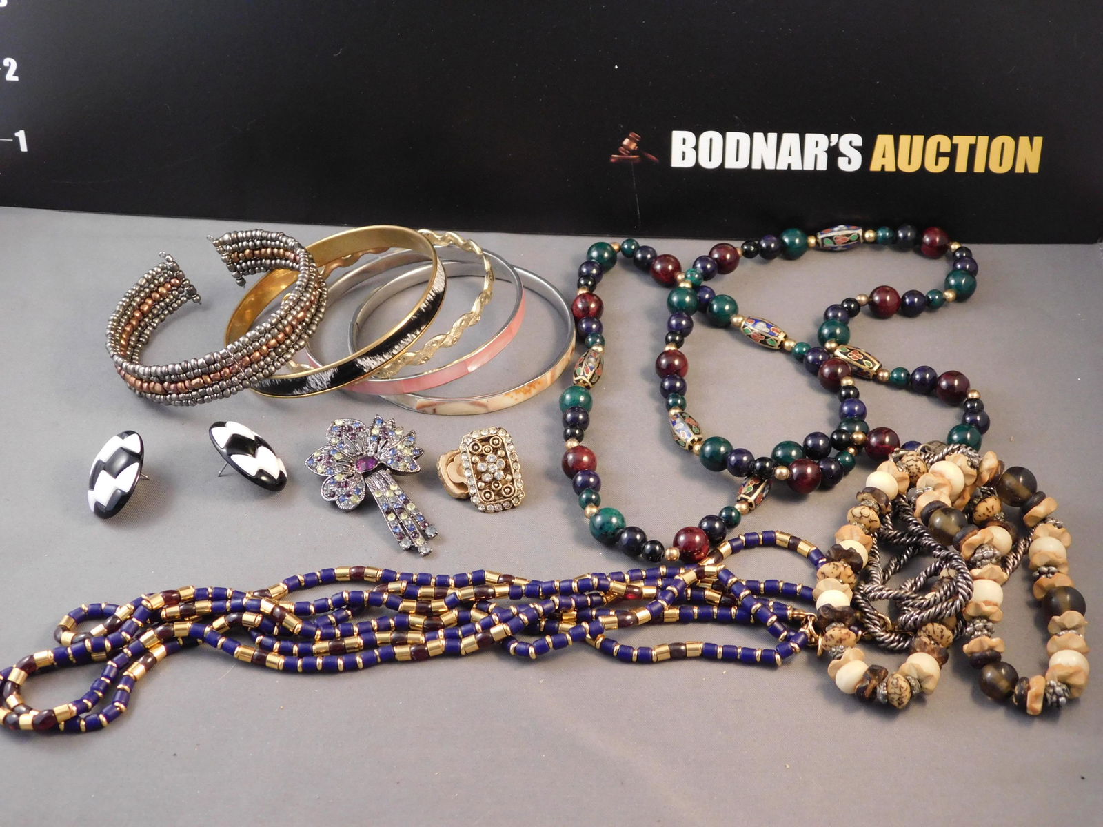 Lot of Costume Jewelry: Lot of costume jewelry. You are bidding at a live sale. Please read the terms and conditions. This sale will be broadcast live on sale day with full descriptions of each lot being sold, as well as vid