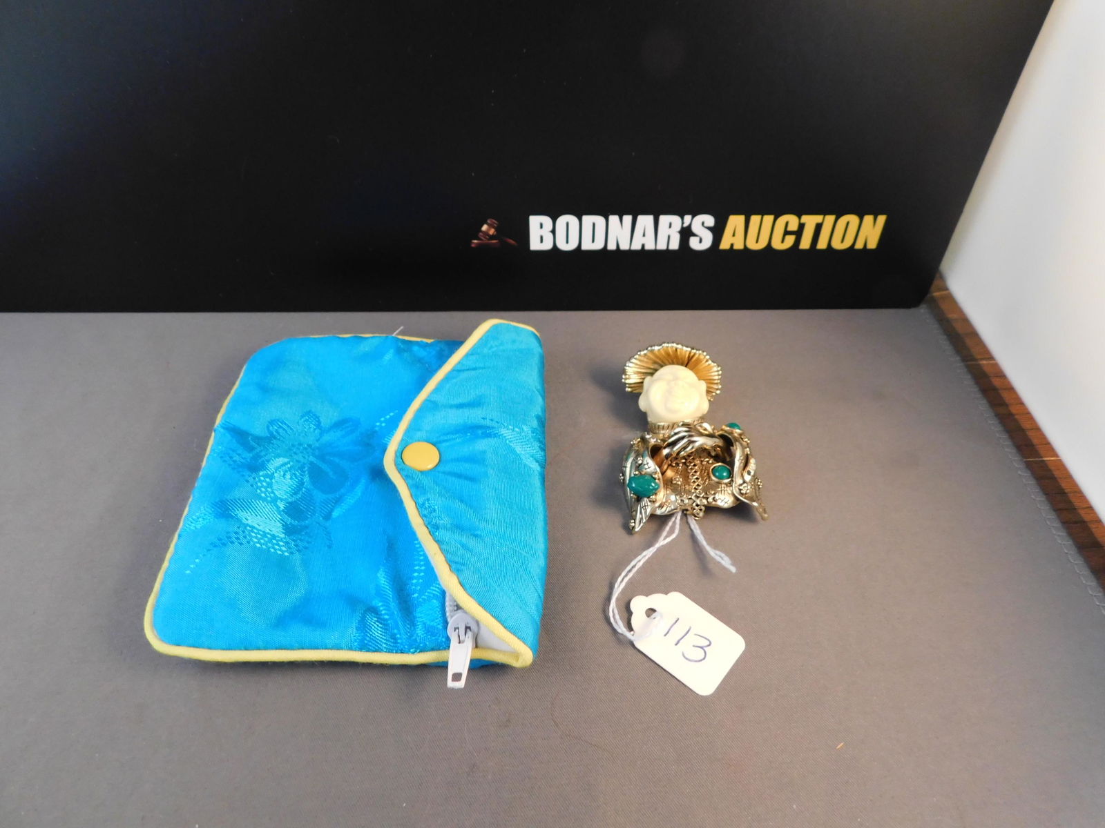 Signed Oriental Asian Man Pin: Signed gold tone pin of Asian pin. Set with green stones and crystals. Marked on back with makers logo but hard to read. Made in China. Missing a few crystals. Measures 2". You are bidding at a live s