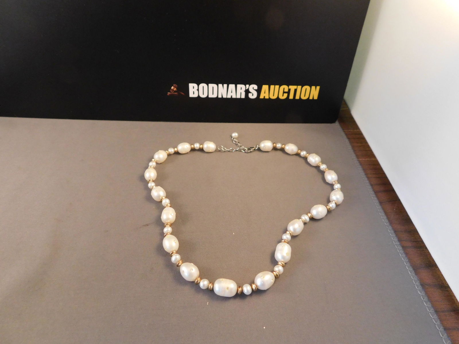 Pearl Necklace: Pearl necklace set with small clear stones and a sterling clasp with gold tone accents. Measures approx. 16". .You are bidding at a live sale. Please read the terms and conditions. We are offering no