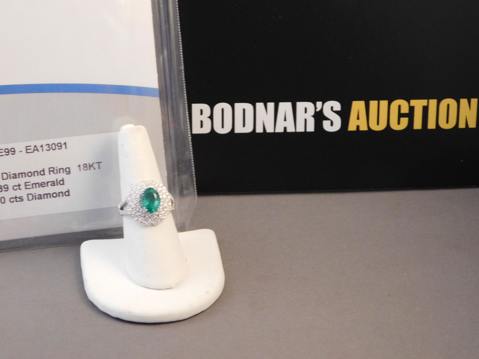 18K Emerald and Diamond Ring: 18K ring with a 1.89 ct emerald center stone and 1.10 ctw diamonds. Size 7. You are bidding at a live sale. Please read the terms and conditions. This sale will be broadcast live on sale day with full