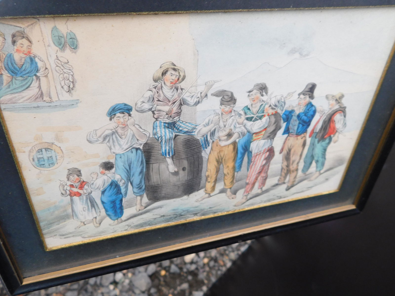 Hand Colored Print Music Scene at Beach: Hand Colored Framed Print depicting a music scene at shore. Image measures 9" L x 6" t You are bidding at a live sale. Please read the terms and conditions. We are offering no contact pick up at our S