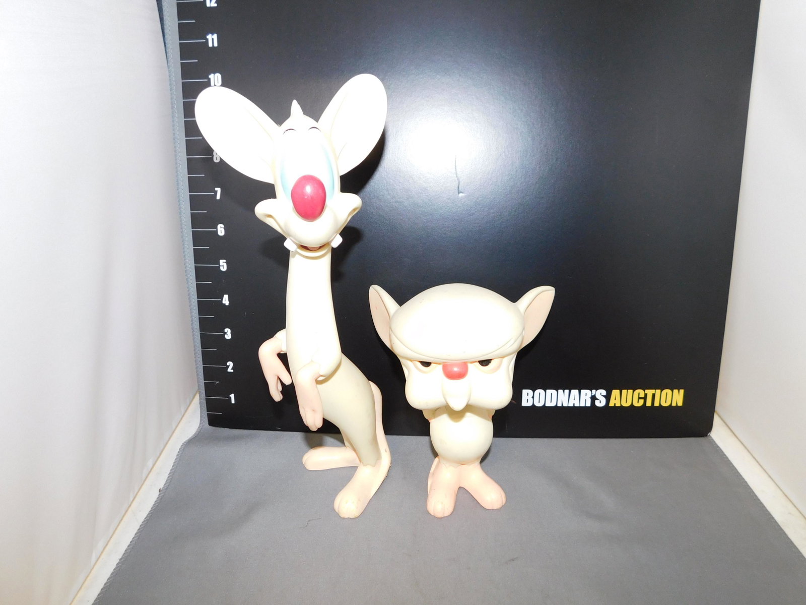Warner Brothers Pinky and the Brain Vinyl Figures: Warner Brothers Pinky and the Brain vinyl figures. Both have condition issues throughout, the back of Pinky's feet appear to have melt spots. Measures approx. 5 1/4" - 10" tall. You are bidding at a l