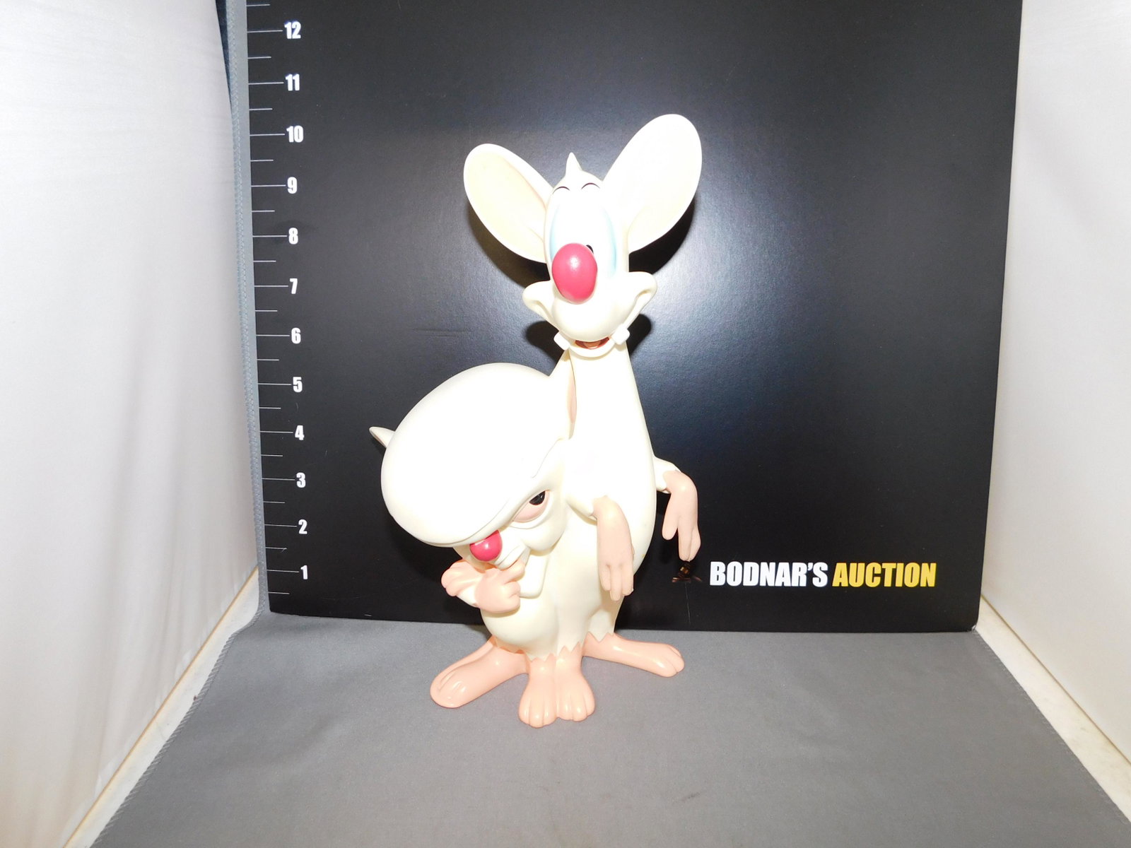 Warner Brothers Pinky and the Brain Vinyl Figure: Warner Brothers Pinky and the Brain vinyl figure. Are in very good condition with a few discoloration spots. Measures approx. 10" tall. You are bidding at a live sale, please read the terms and condit