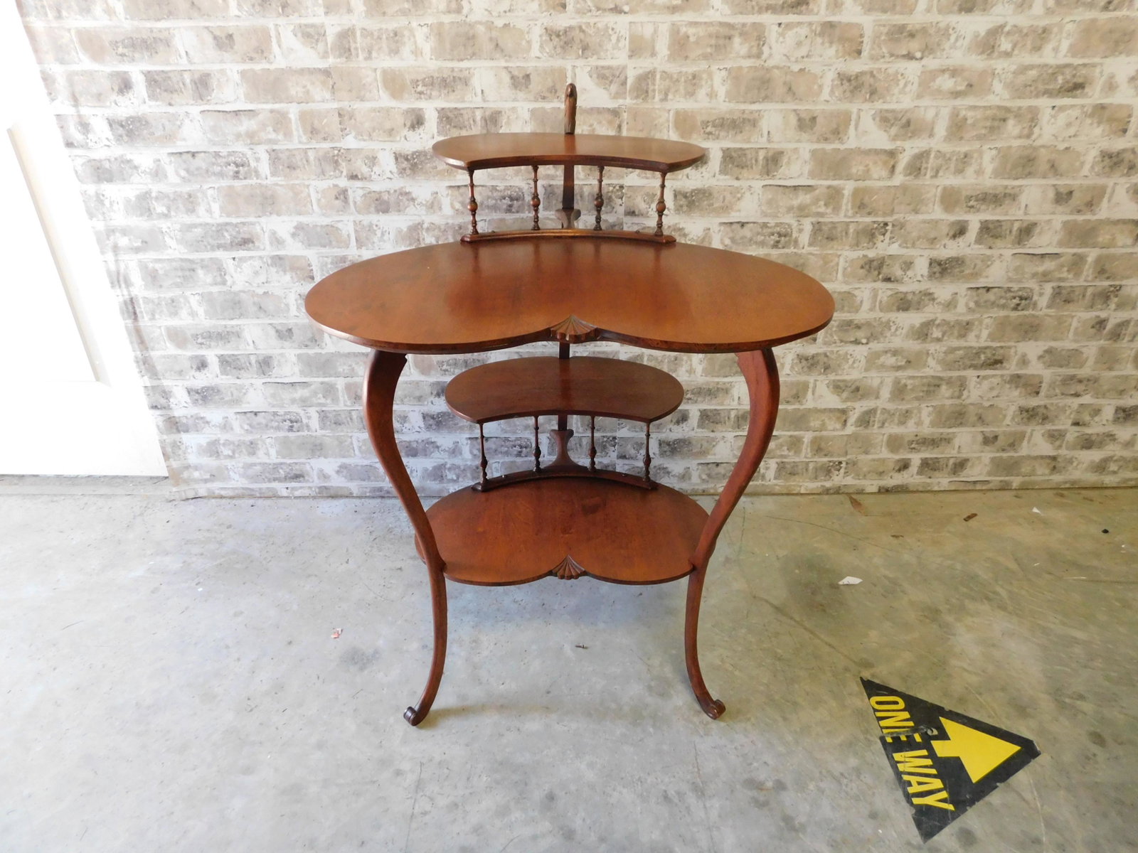 1920's Serpentine 4 Tier Stand: 1920's Serpentine Front 4 Tier Stand with Column Support and Carved Dragon Head Design. Poss. Huntzinger. In pristine condition. Measures 34" tall x 25" w x 23" d. You are bidding at a live sale. Plea