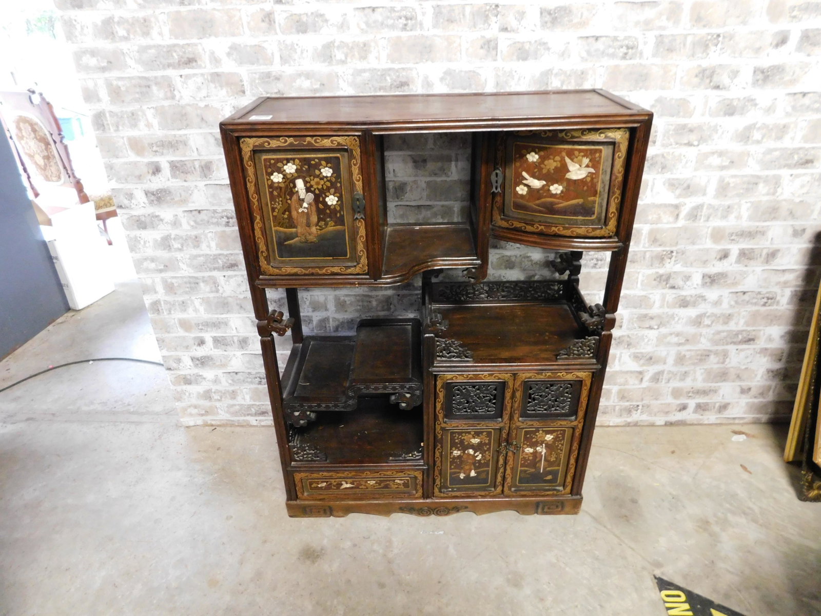 Asian Hand Carved and Mother of Pearl Inlaid Curio: Asian Hand Carved and Mother of Pearl Inlay Open Curio. Needs some TLC but overall in good condition. Measures 41" tall x 31" w x 12" d. You are bidding at a live sale. Please read the terms and condi